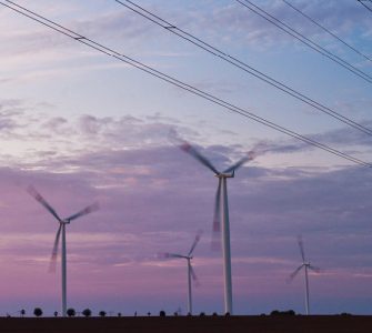 Windkraftturbinen und Ueberlandleitungen im Morgenlicht